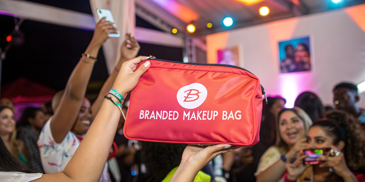 a branded makeup bag being held up at a lively social media event