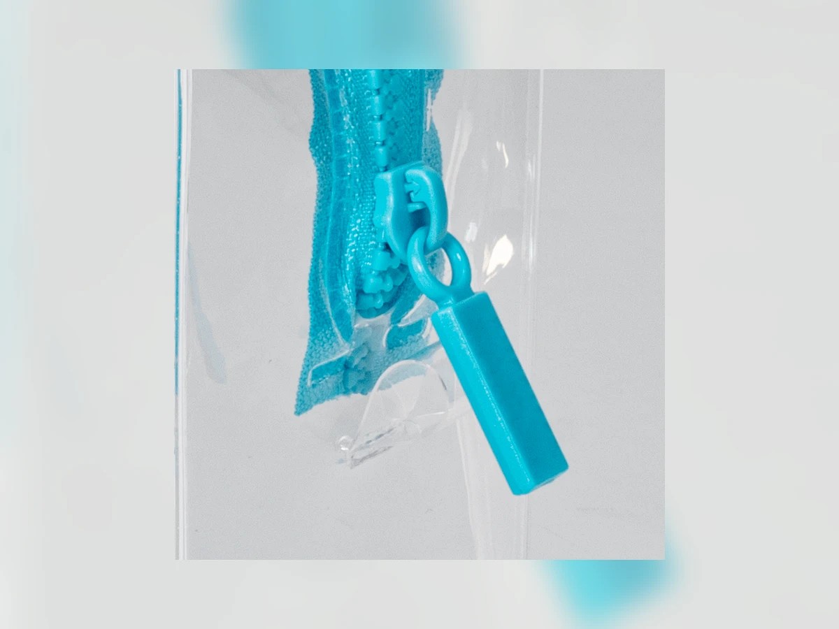 Clear pouch zipper puller and transparent material close-up for hardware QC