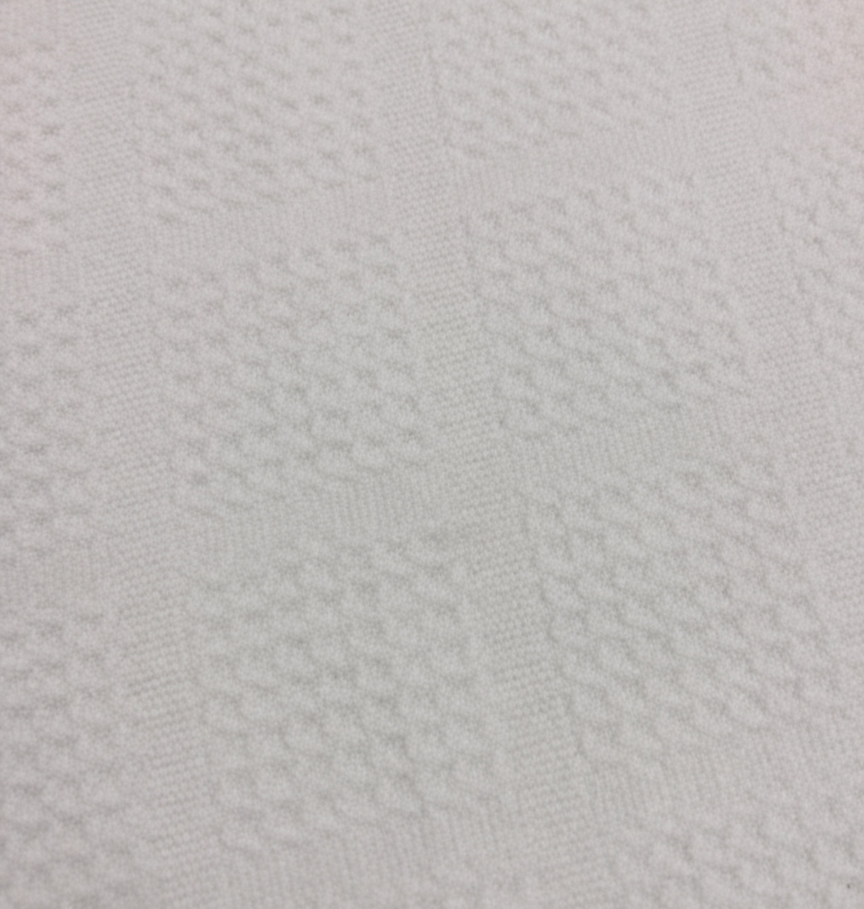 Close view of a flat woven band interrupting a waffle microfiber surface